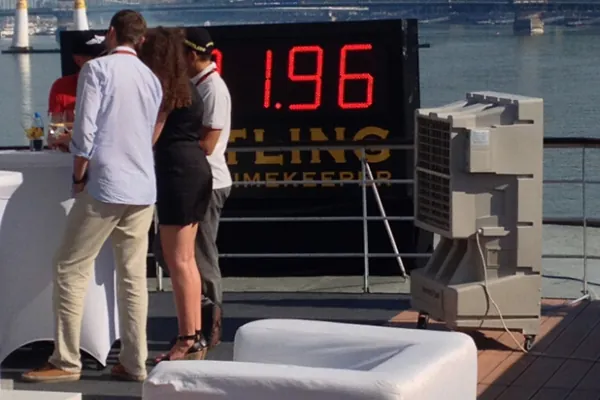 Climatizador evaporativo portátil grande ECO-12000 en un evento junto a una pantalla con números rojos