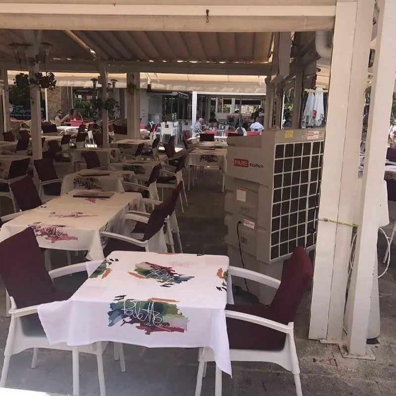 Climatizadores evaporativos ECO-12000 en una terraza cubierta con mesas y sillas