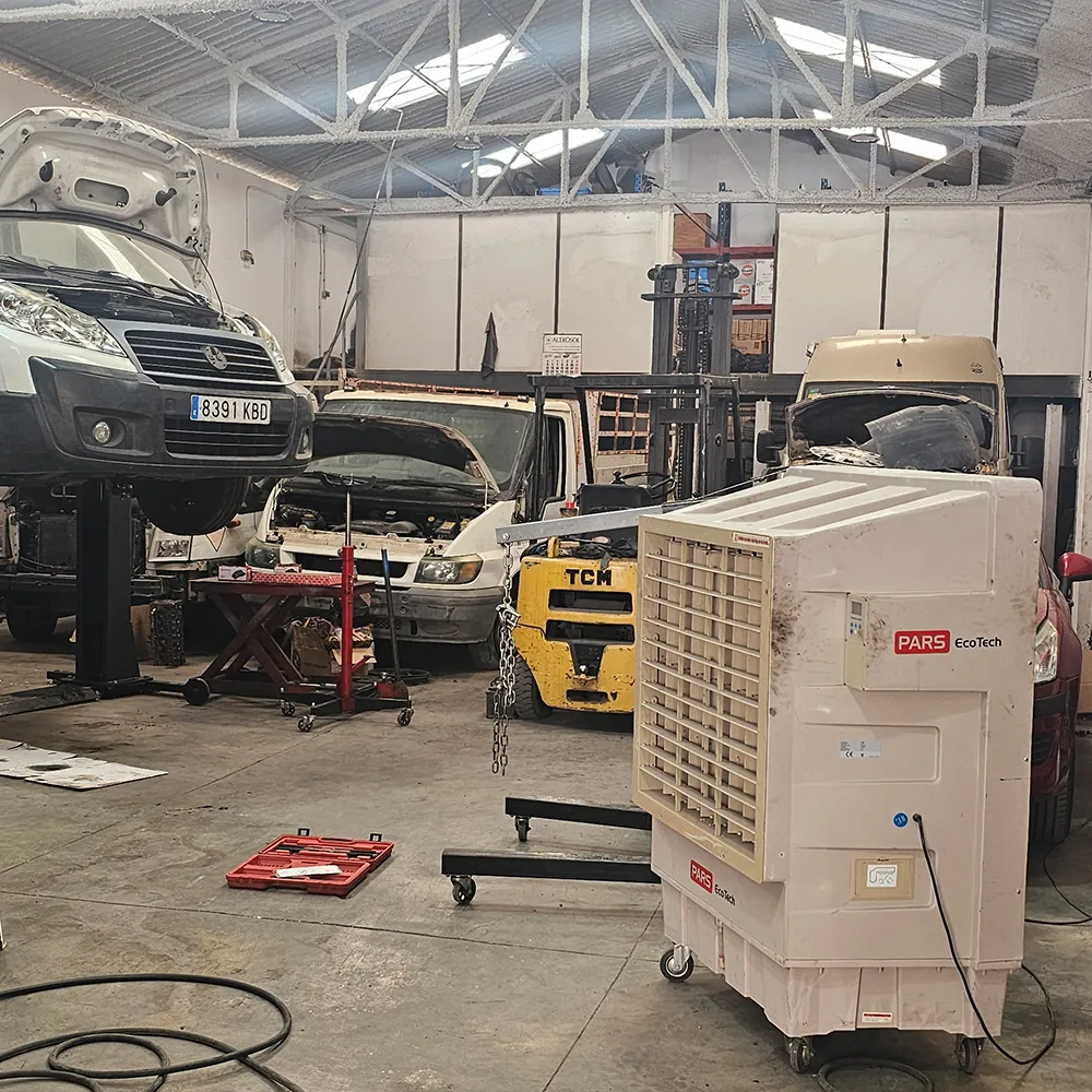 کولر تبخیری ECO-18000 در یک تعمیرگاه مکانیکی با ون‌های روی بالابر و یک مکانیک در حال کار
