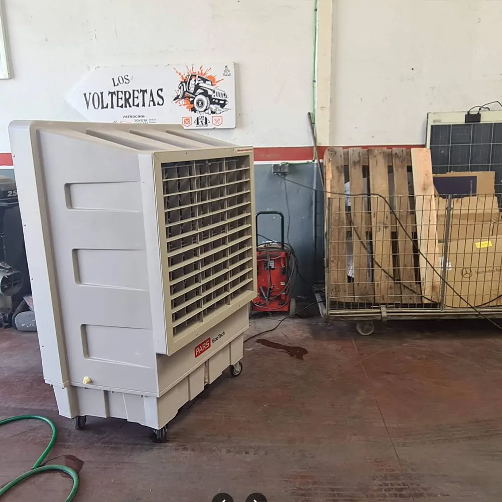 کولر تبخیری ECO-18000 در یک تعمیرگاه مکانیکی کنار پالت‌ها و تابلویی روی دیوار