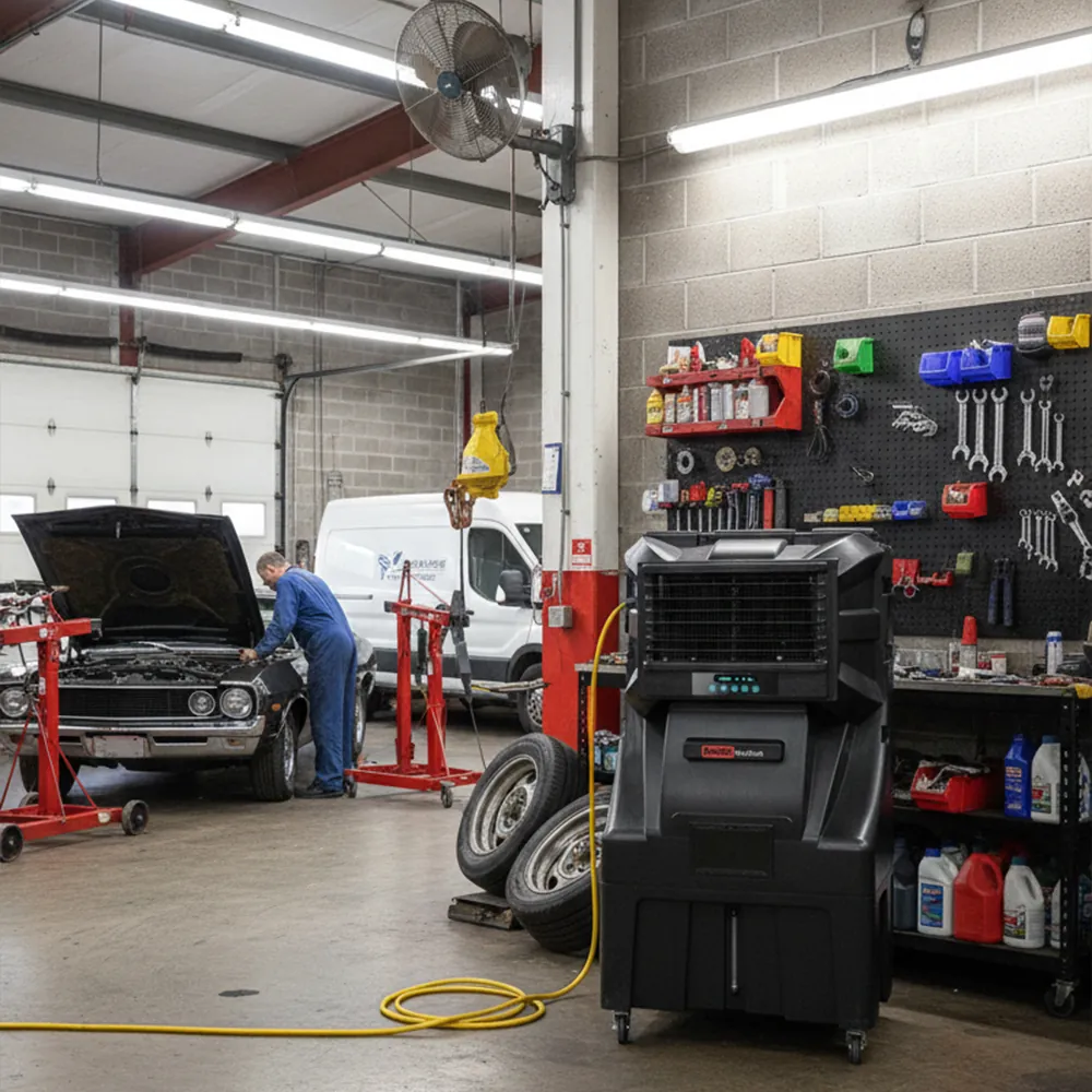 Climatizador evaporativo ECOsport-23000 en un taller mecánico junto a un coche con el capó abierto y un mecánico trabajando